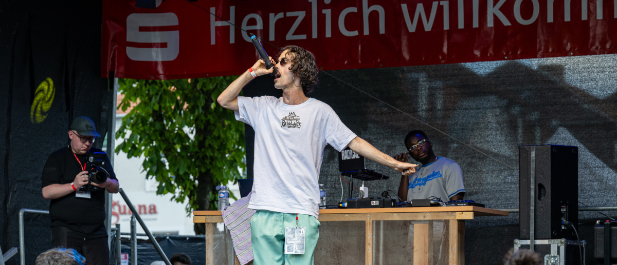 Eine Rap-Crew performt mit sichtbarer Energie auf der Bühne. 