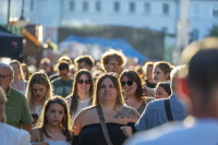 Besucherinnen und Besucher gehen bei tief stehender Sonne über den Marktplatz.