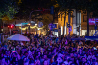 Dichtes Publikum steht nachts auf Markt mit beleuchteten Lampions.